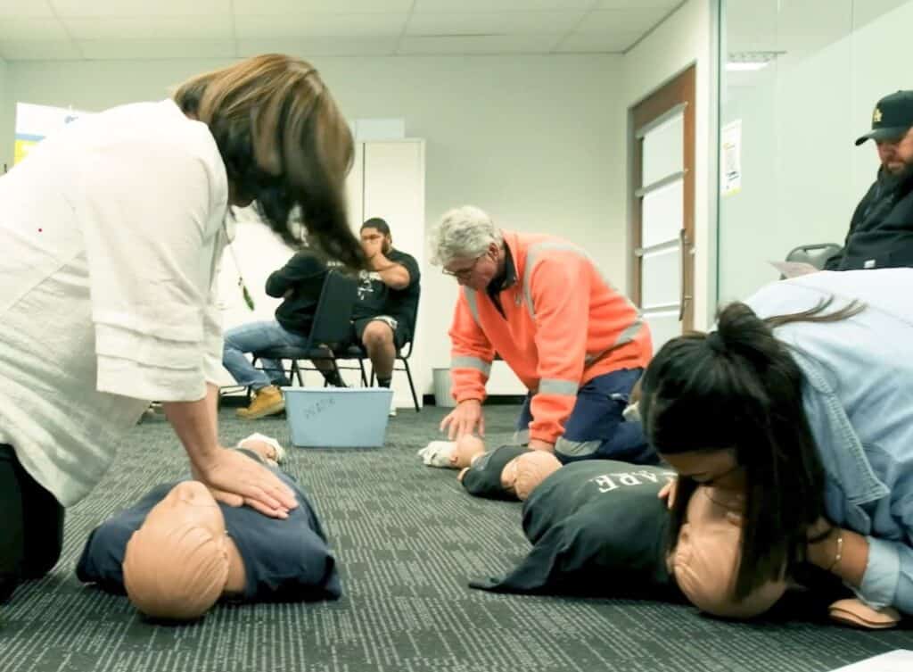 Participants in a Life Care CPR training session practicing on mannequins.