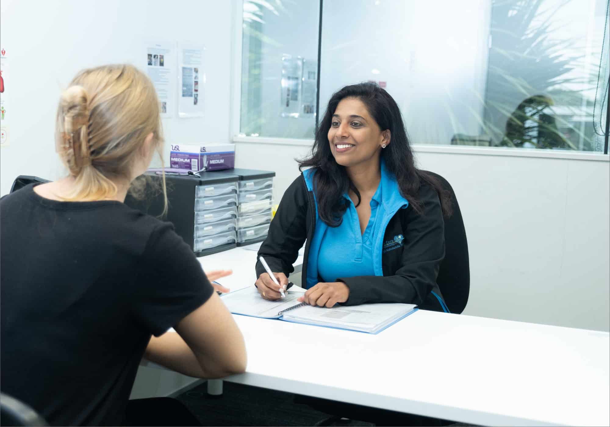 Life Care staff member smiling during a workplace health consultation with a client.